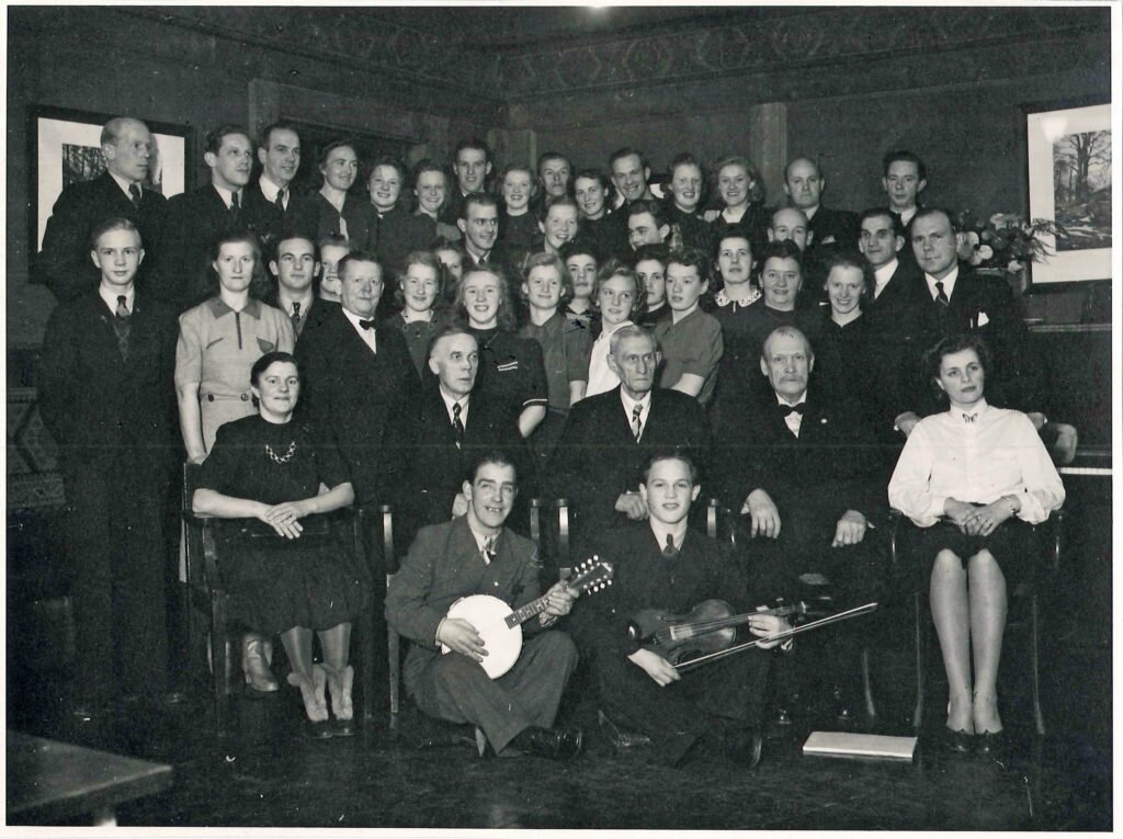 Ca 45 personer uppställda för fotografering i en cafélokal.